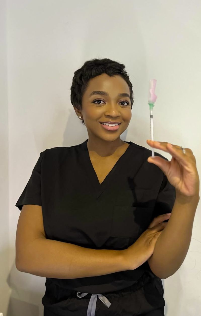Moreblessing Muchegwa, founder of Pulse & Glow Clinic, holding an aesthetic treatment syringe